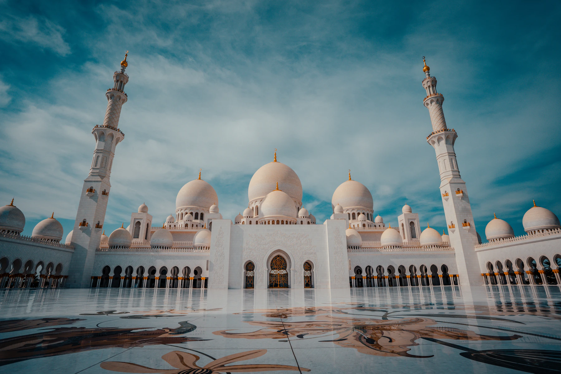 Sheikh Zayed Grand Mosque in Abu Dhabi with white domes, minarets and its marble courtyard