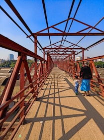 a man and a child walking across a bridge