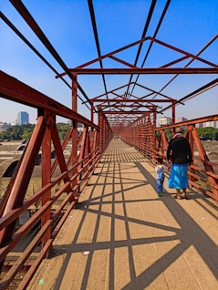 a man and a child walking across a bridge