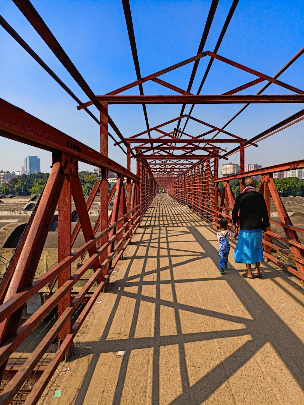 a man and a child walking across a bridge