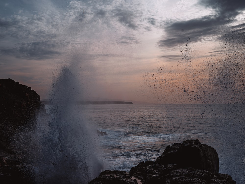 a large wave crashing into the shore of the ocean