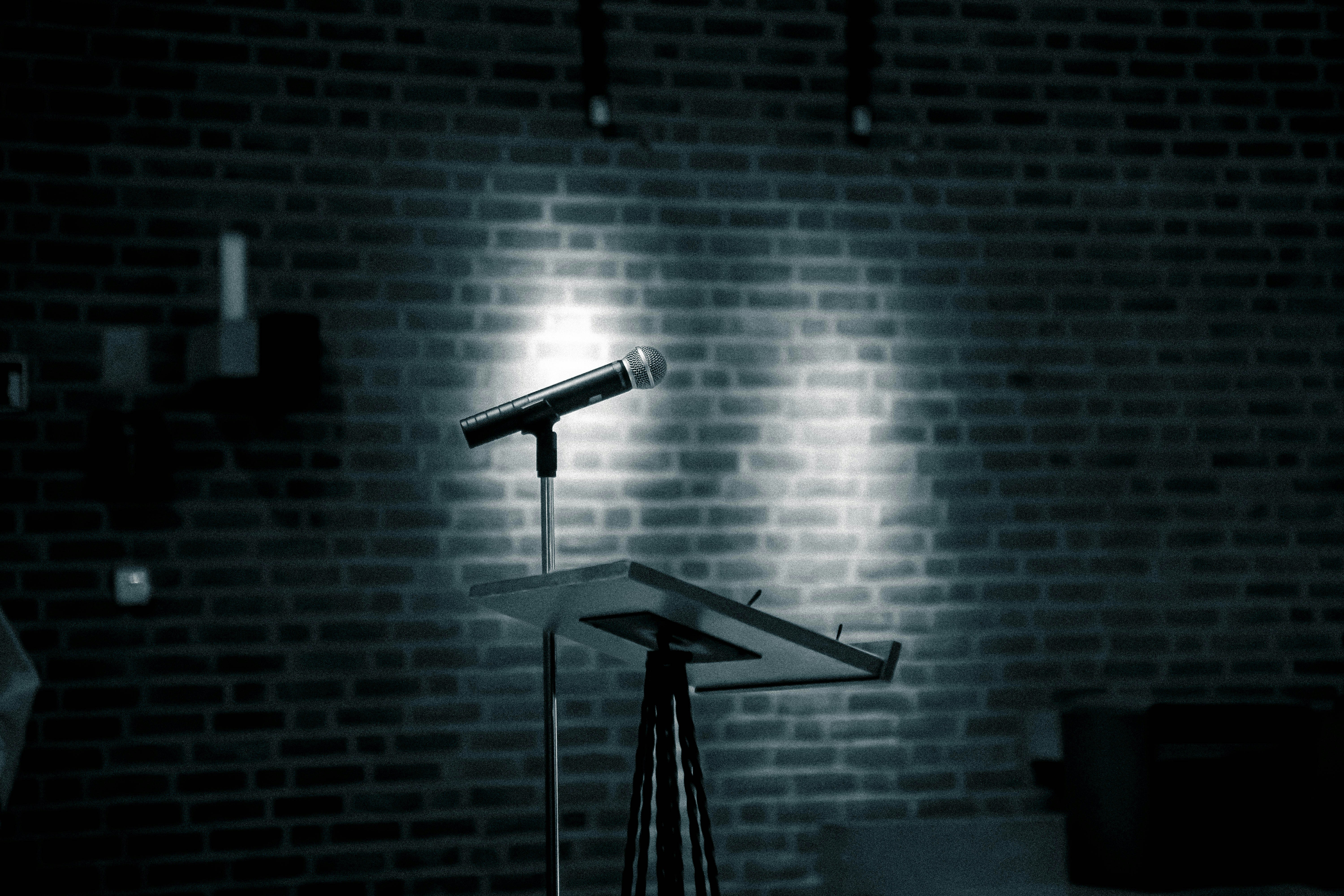 a microphone on a stand in front of a brick wall