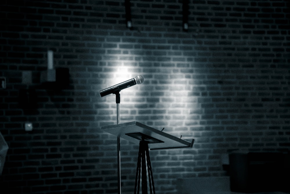 a microphone on a stand in front of a brick wall