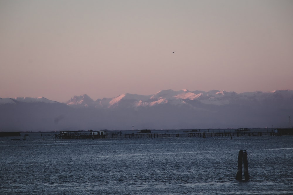 a large body of water with mountains in the background