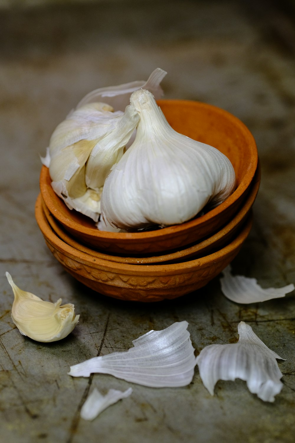 a wooden bowl filled with garlic on top of a counter