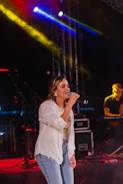 a woman standing on top of a stage holding a microphone