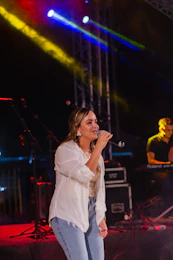 a woman standing on top of a stage holding a microphone