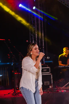 a woman standing on top of a stage holding a microphone