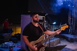 a man playing a bass guitar on stage