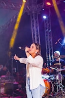 a woman standing on top of a stage holding a microphone