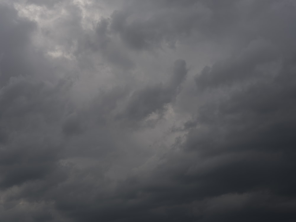 a plane flying through a cloudy sky on a cloudy day