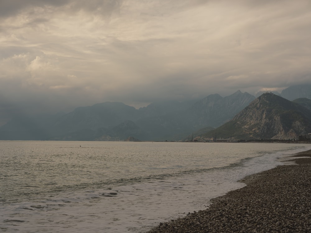 a body of water with mountains in the background