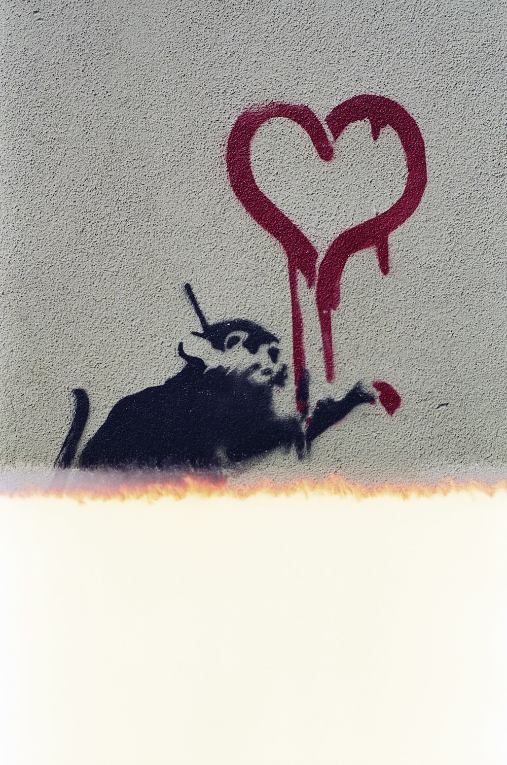 a painting of a cat and a heart on a wall