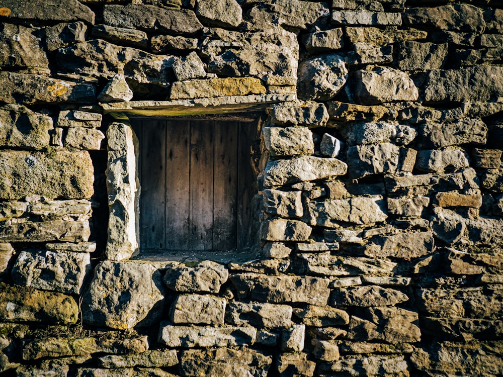 a stone wall with a small window in it