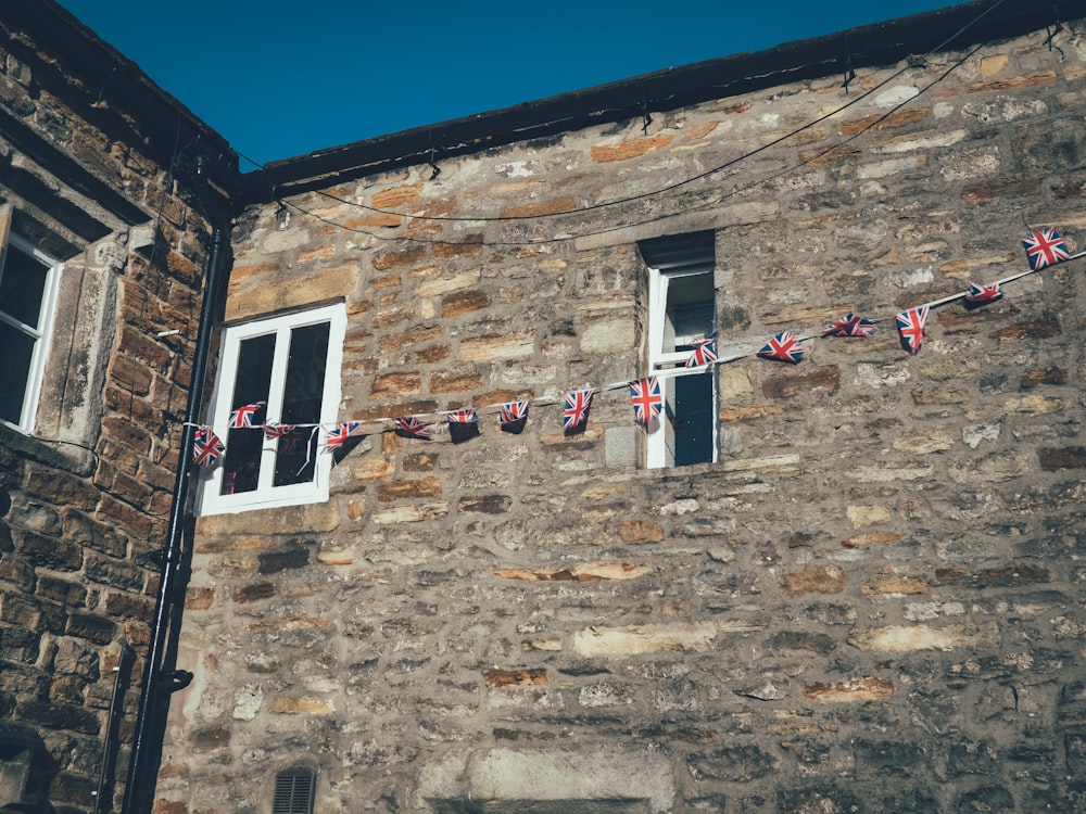 a stone building with a bunch of flags hanging from it's windows