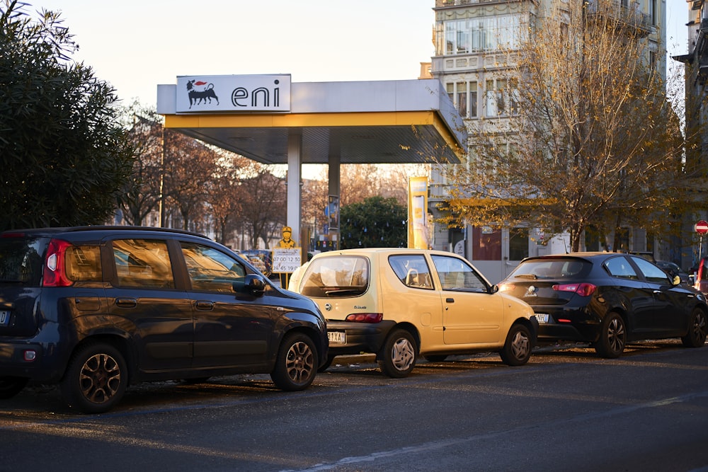 a gas station with cars parked on the side of the road