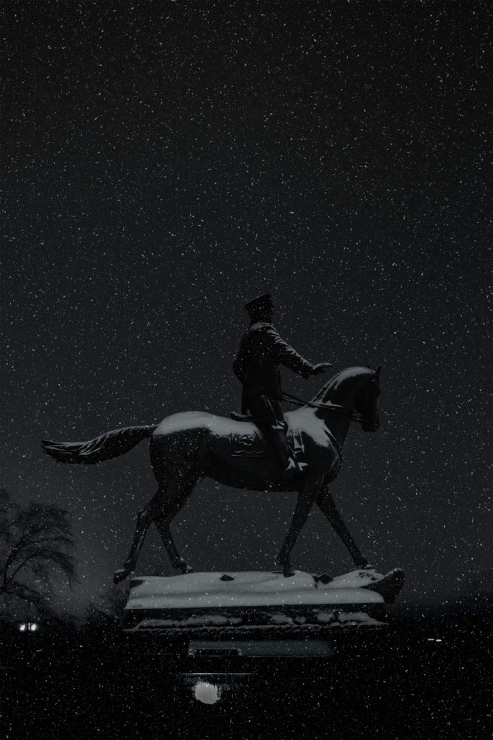 a statue of a man riding a horse in the snow