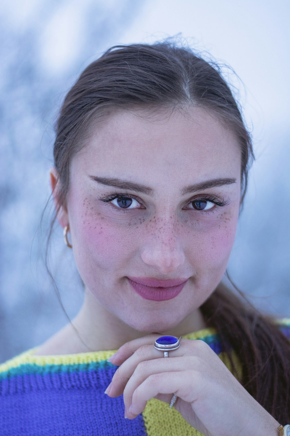 a girl with freckles and a ring on her finger