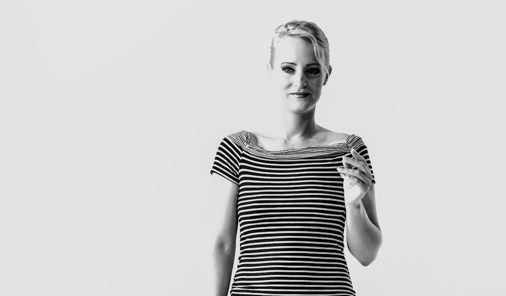 a black and white photo of a woman holding a cell phone