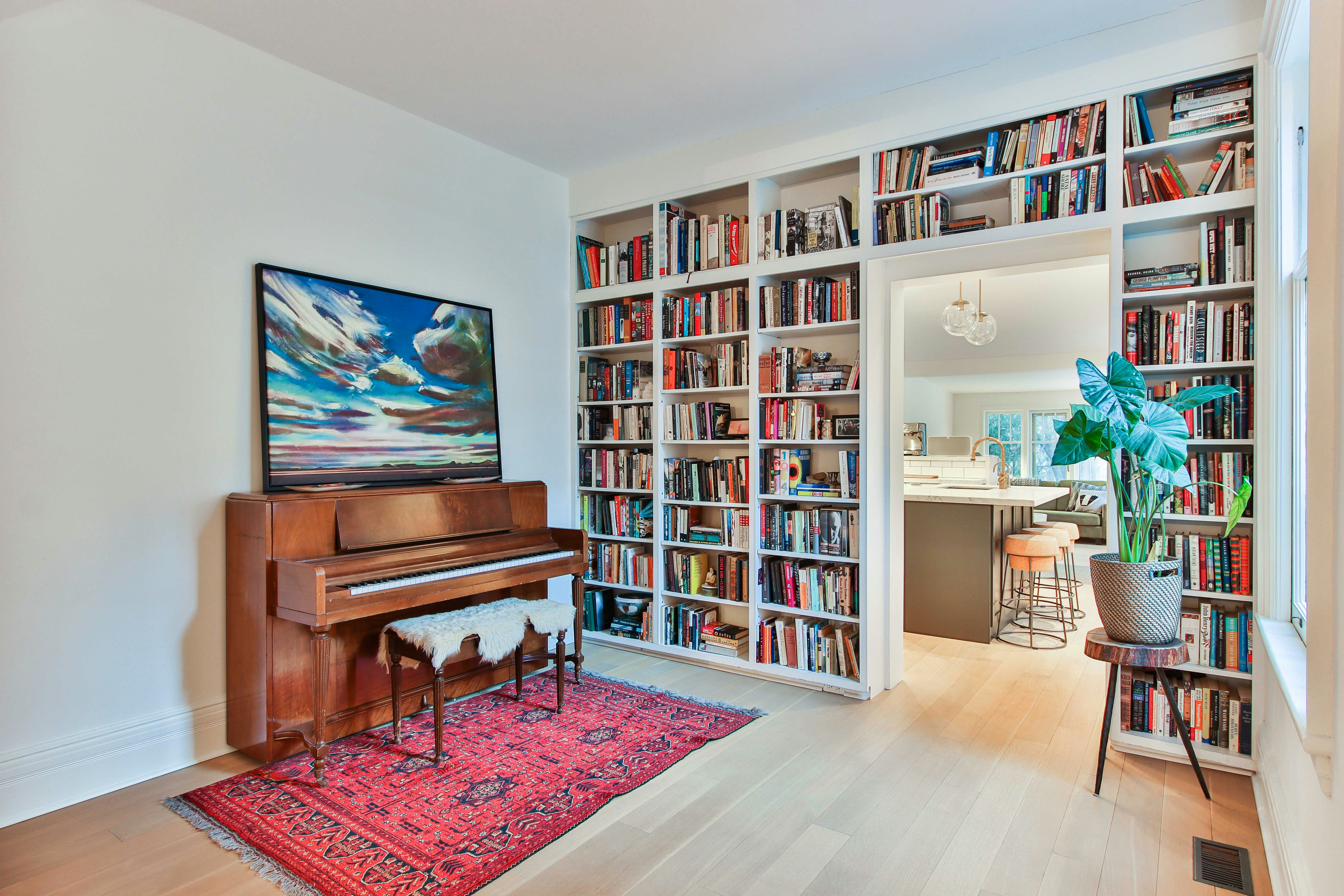 a living room filled with lots of books and furniture