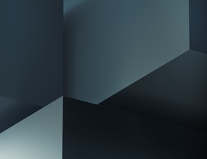 A geometric abstract composition with intersecting planes and sharp angles, creating a sense of depth and dimension. The color palette consists of various shades of dark blue and gray, emphasizing a sleek and modern aesthetic.