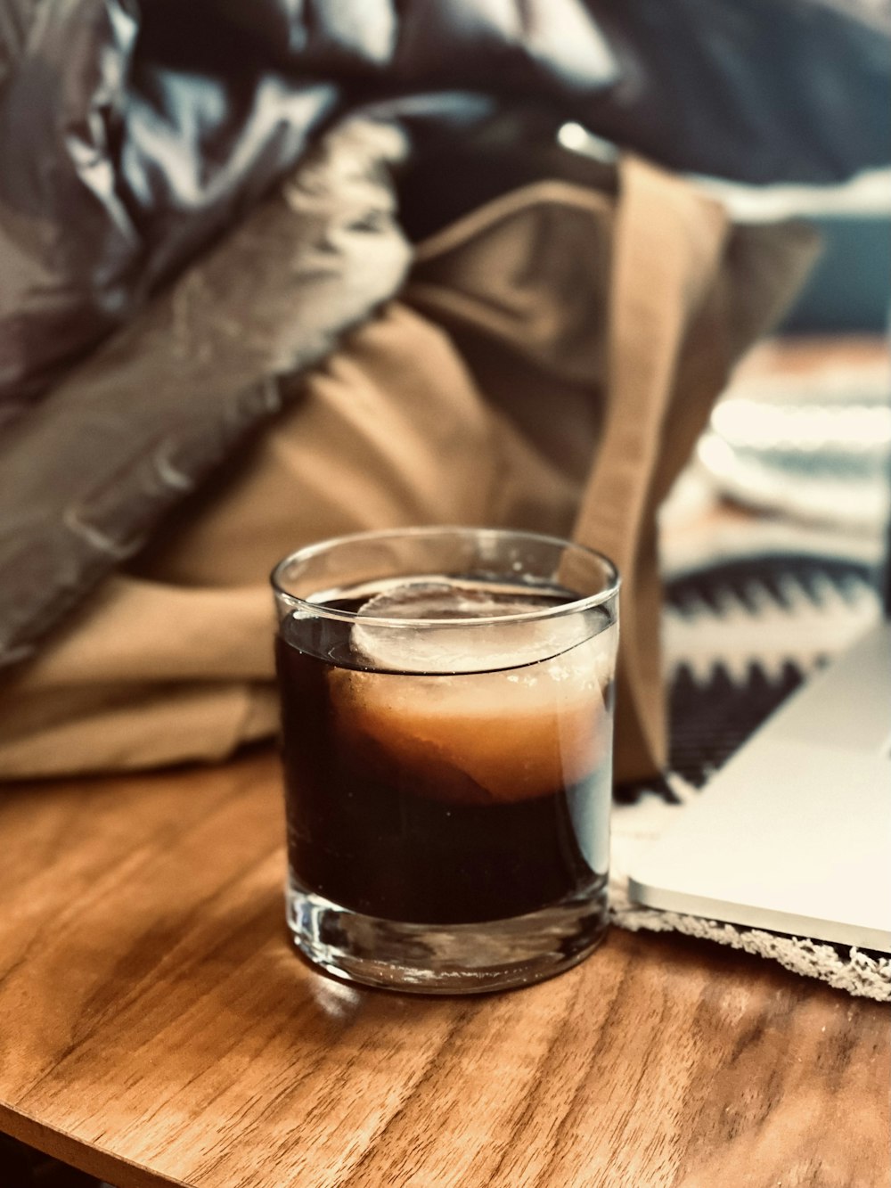 a glass of liquid sitting on top of a wooden table