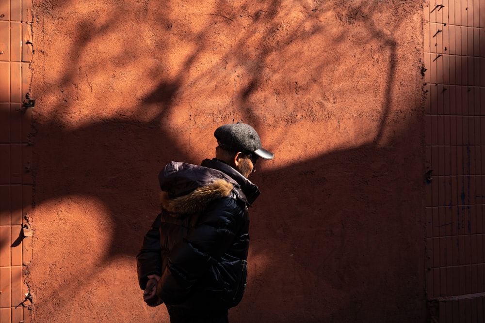 a man standing in front of a red wall