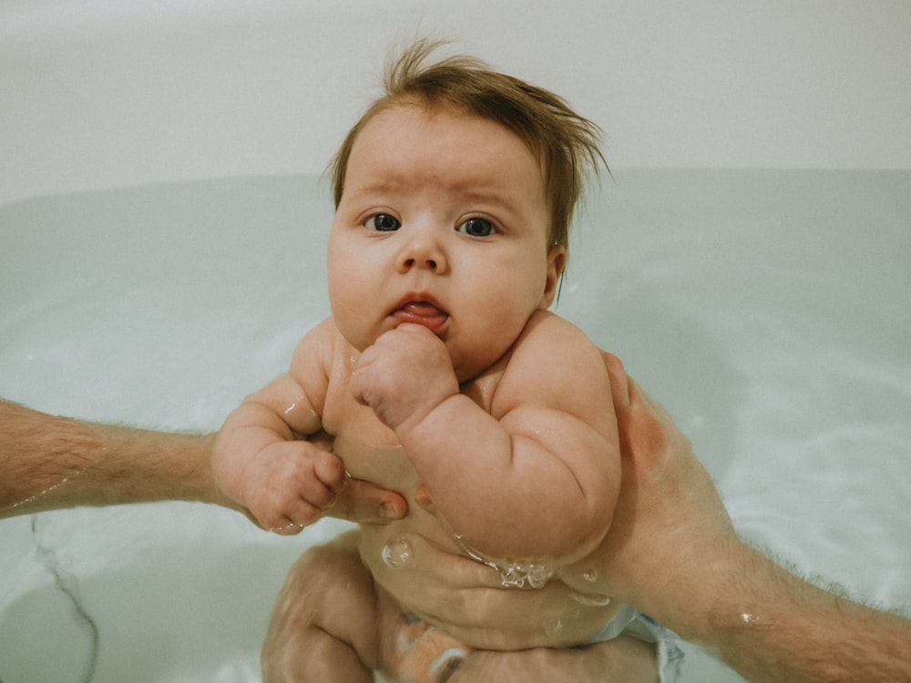 a man holding a baby in a bathtub