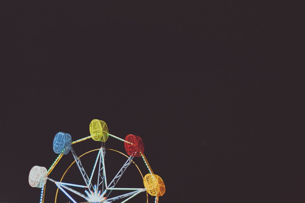 a ferris wheel lit up against a dark sky