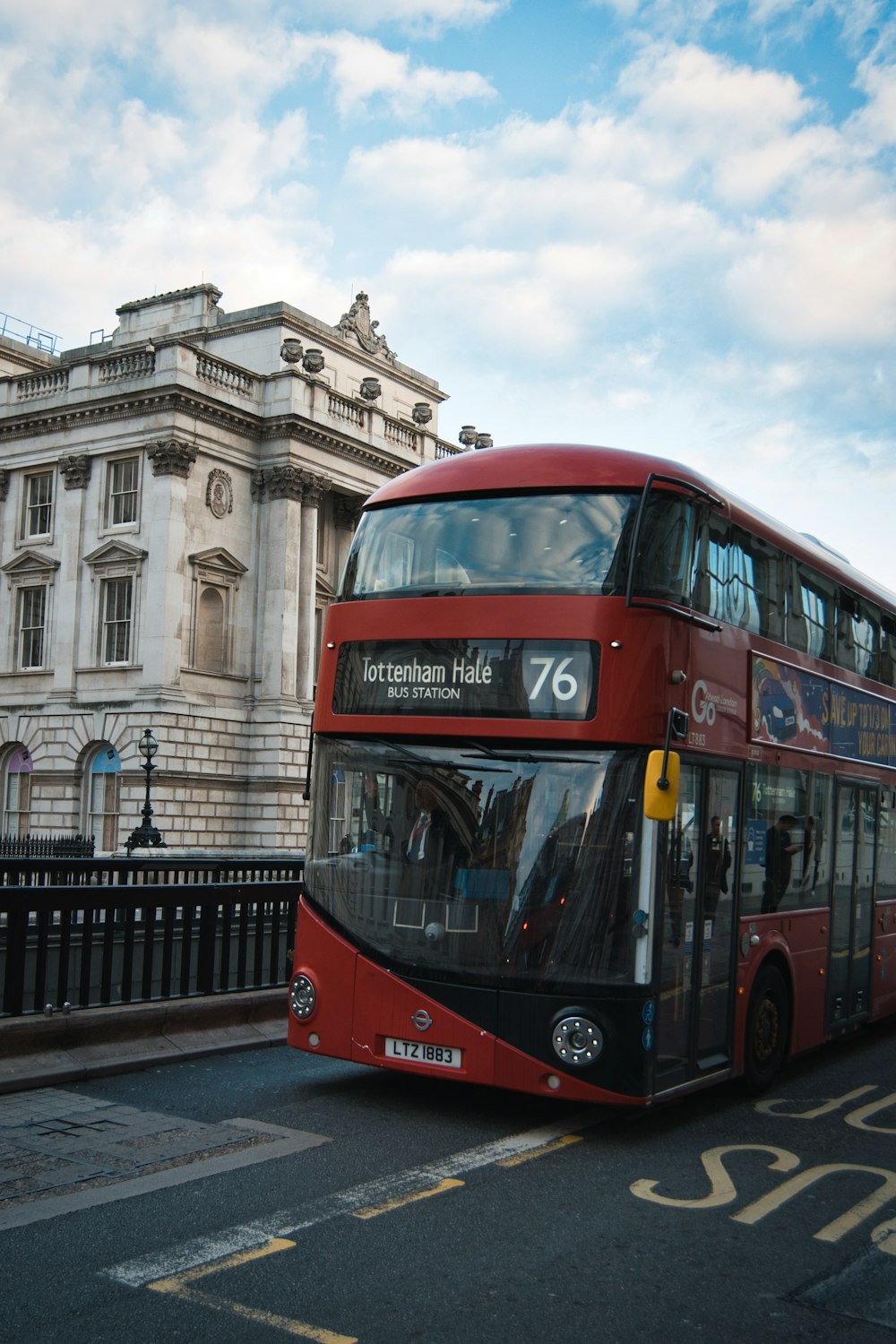 a red double decker bus driving down a street