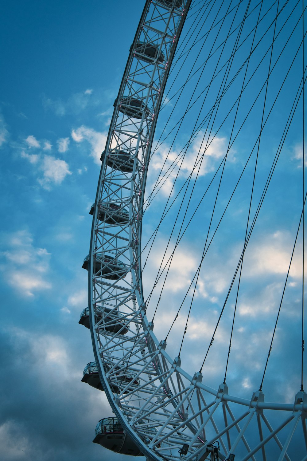 a large ferris wheel against a cloudy blue sky