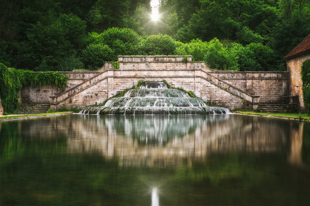 a pond with a waterfall in the middle of it