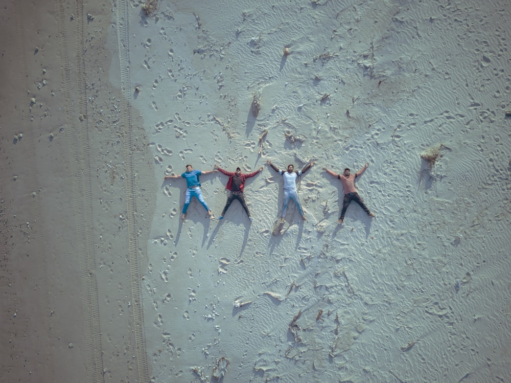 a group of people laying on top of a sandy beach