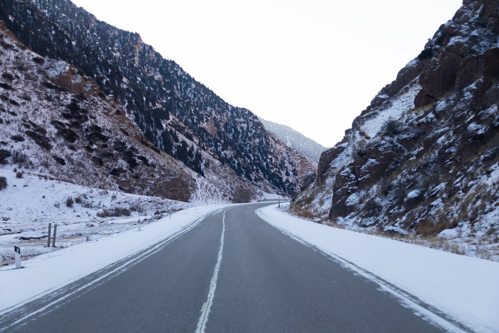 a snowy road with a mountain in the background