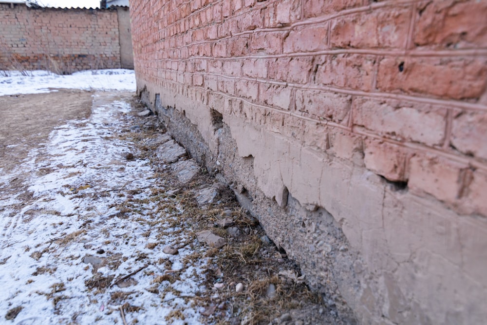 a brick wall that has been partially covered in snow