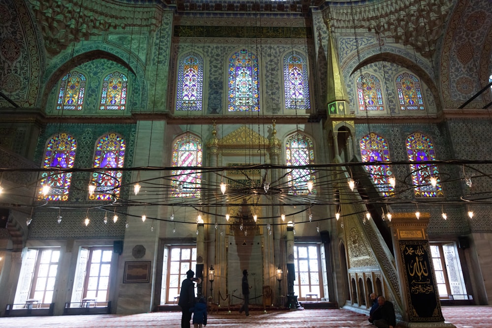 two people standing in a large building with stained glass windows