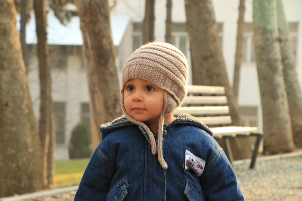 a small child wearing a hat and jacket