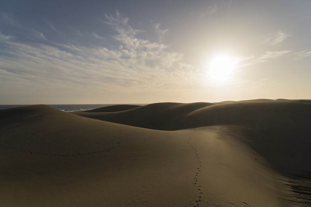 the sun is shining over the sand dunes