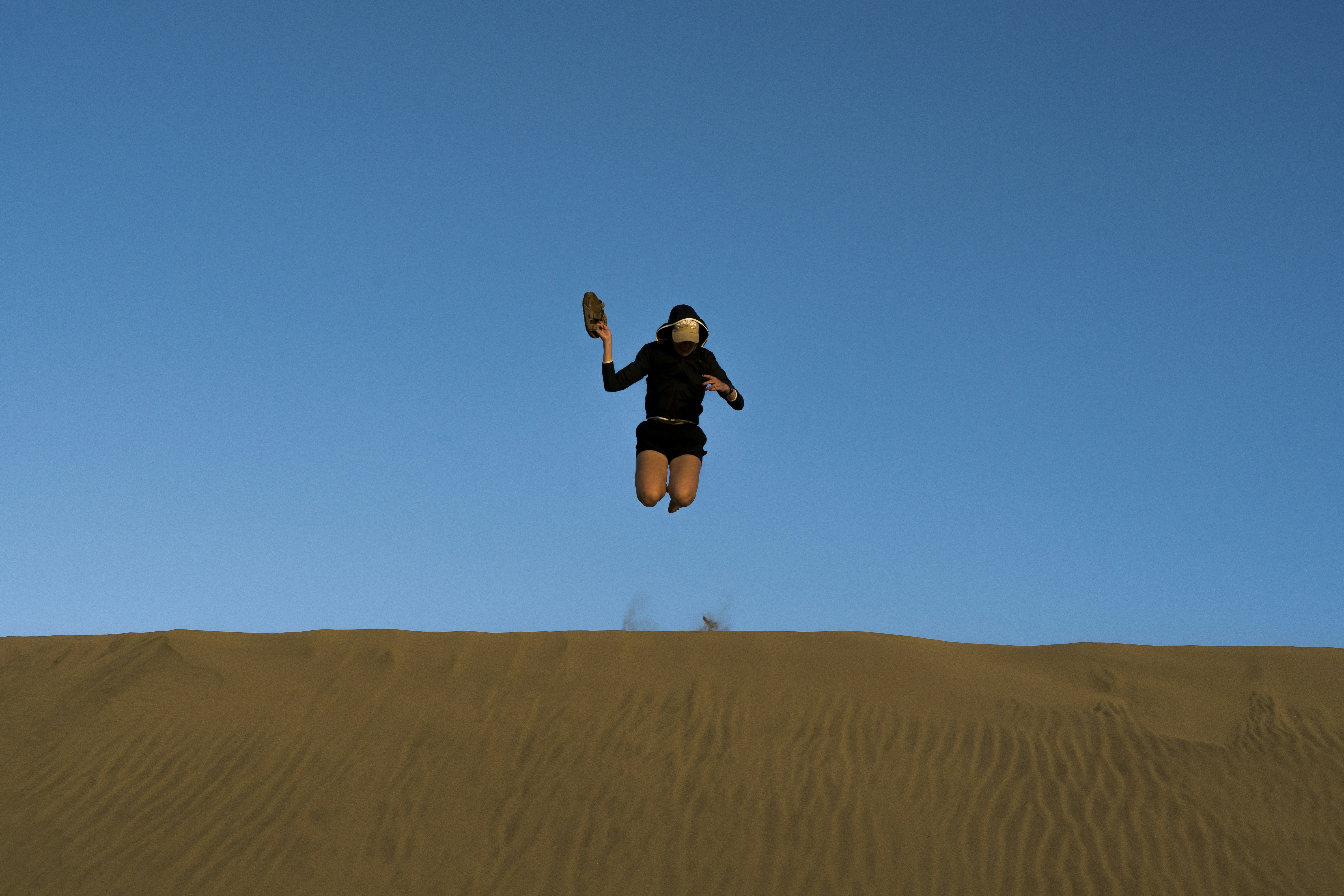 a person jumping in the air with a cell phone