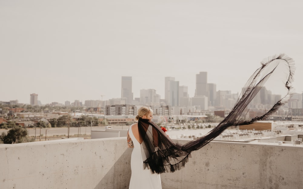 a woman standing on top of a roof next to a tall building