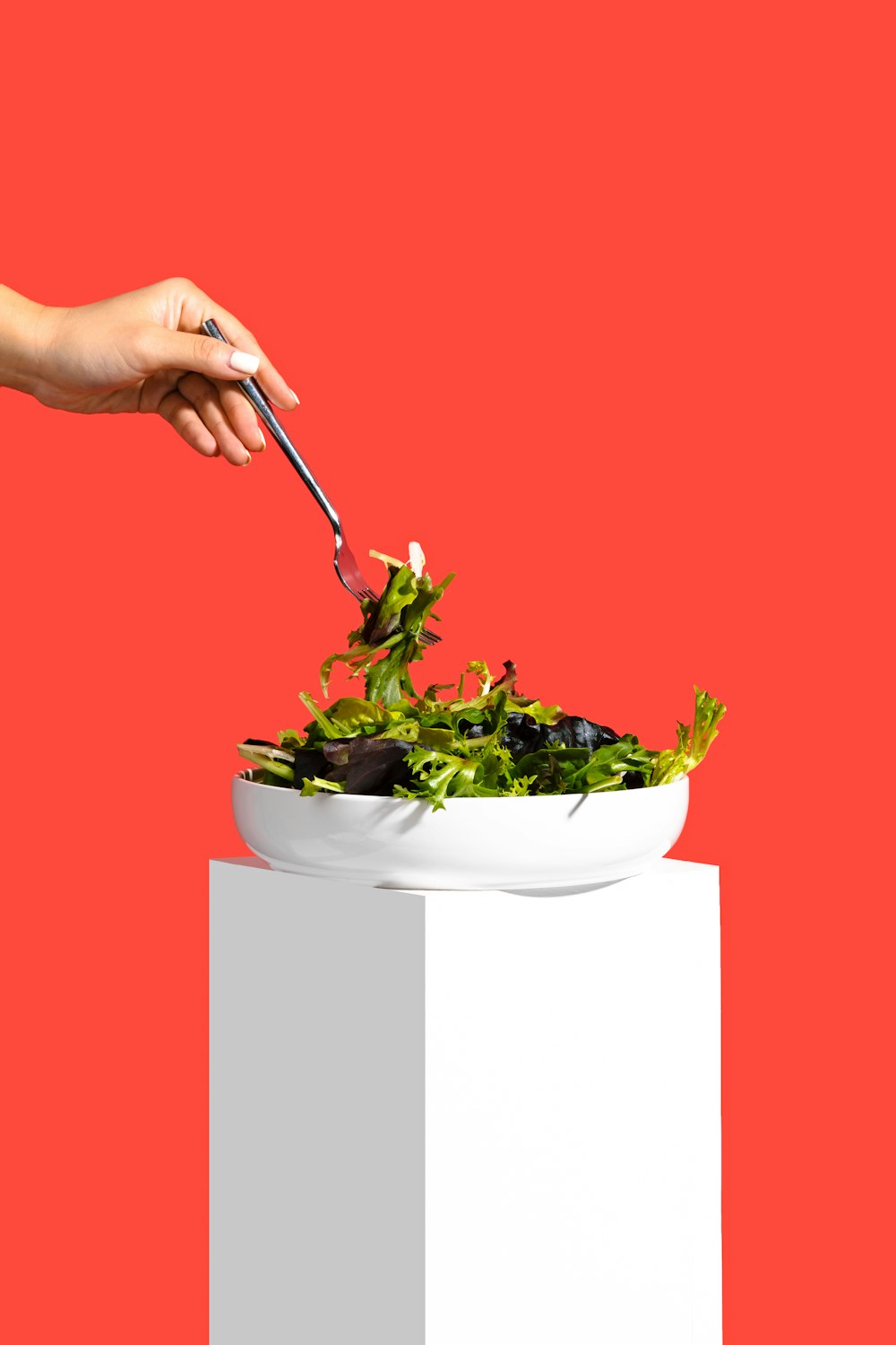 a person is holding a fork over a bowl of food