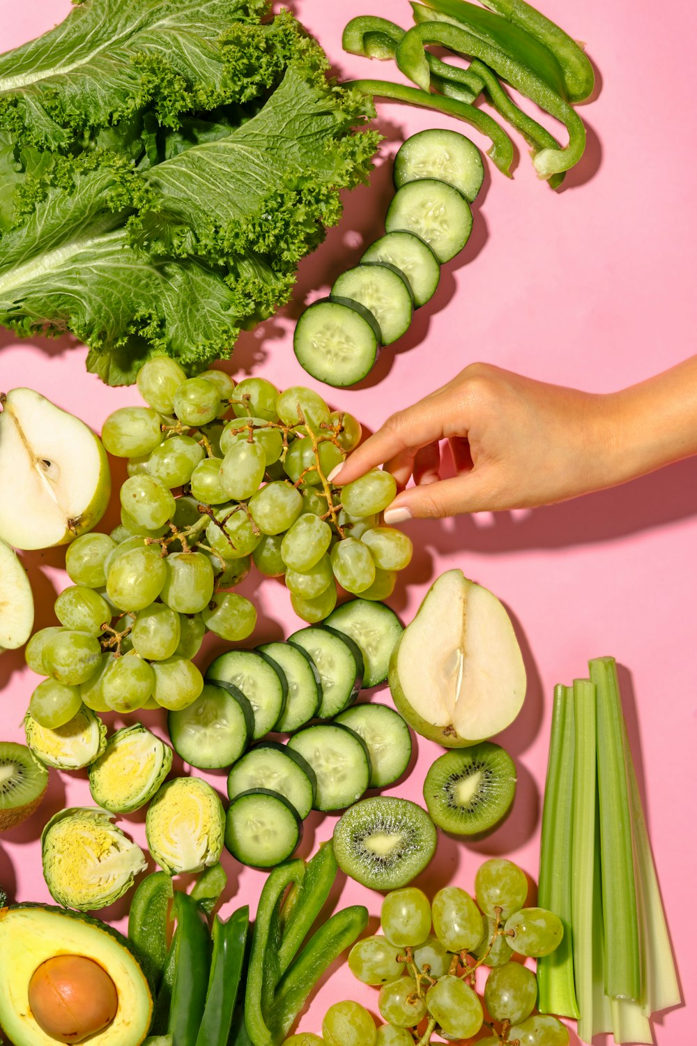 a person reaching for a piece of fruit and vegetables