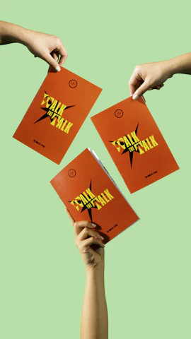 Close-up of hands holding a colorful booklet about antiracism education.