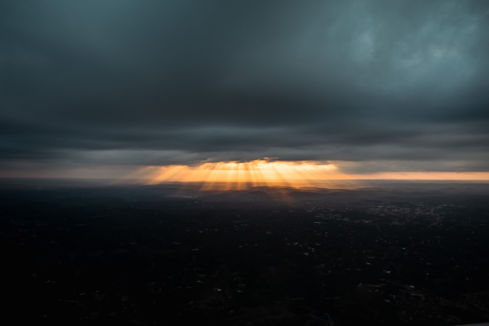 o sol brilhando através das nuvens sobre uma cidade