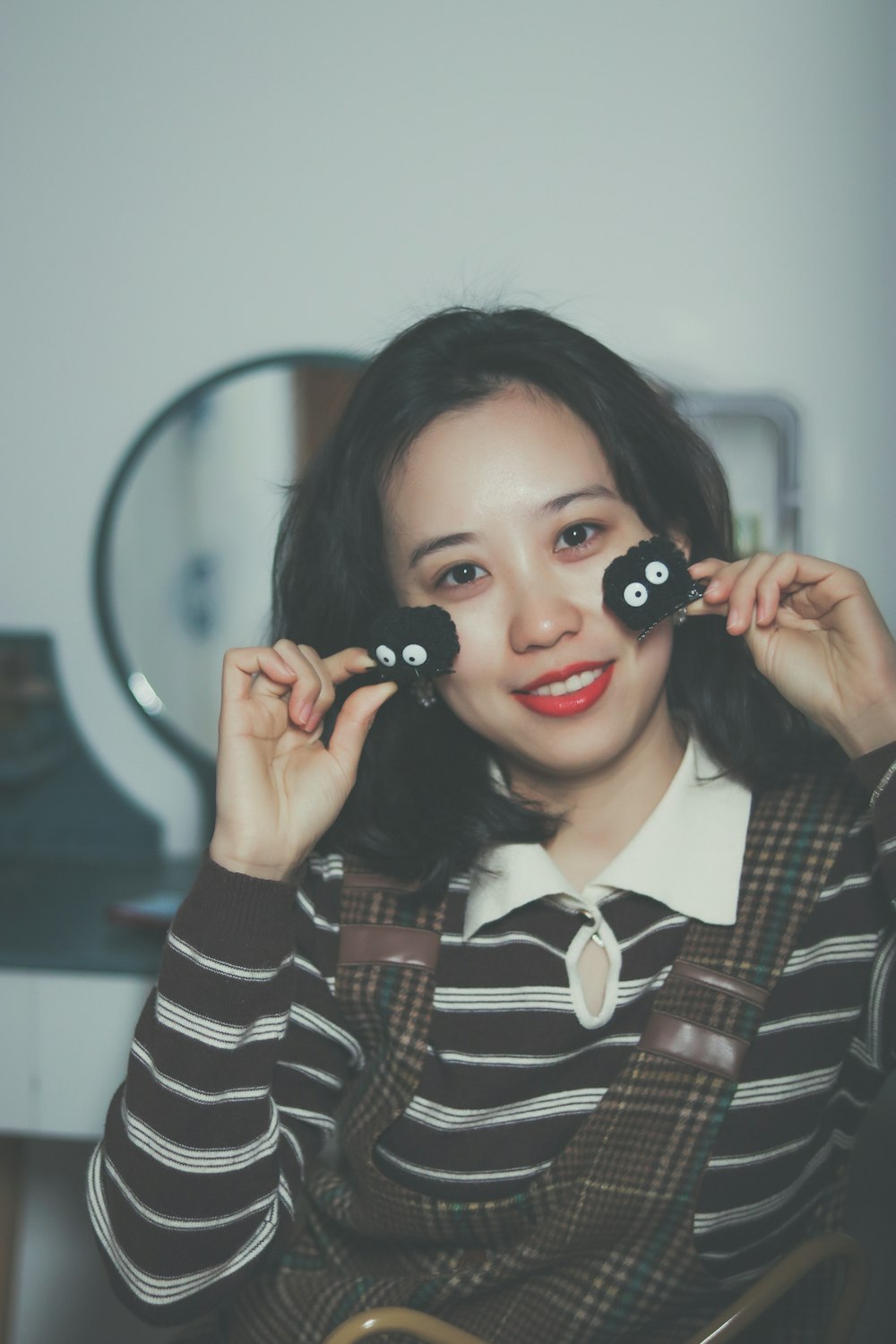 a woman holding two black objects up to her eyes