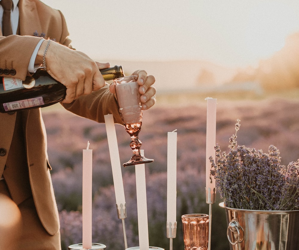 a man in a suit pours a glass of wine