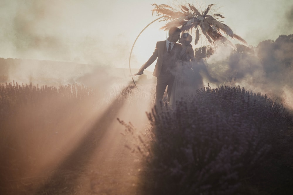 a man and a woman are walking through a field