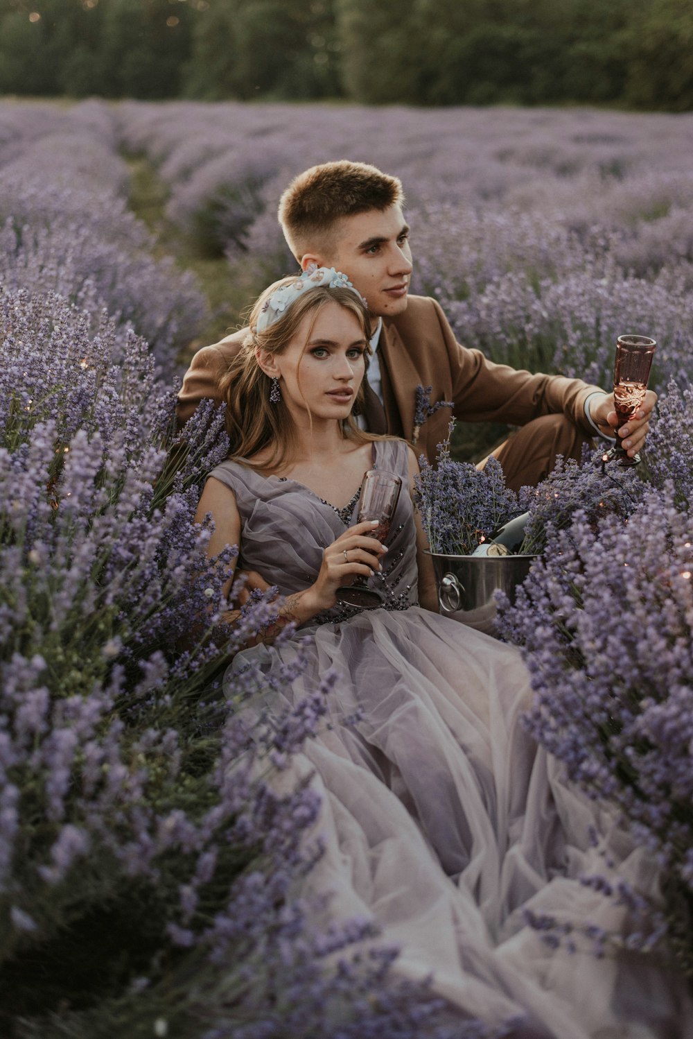 a man and a woman sitting in a field of lavender