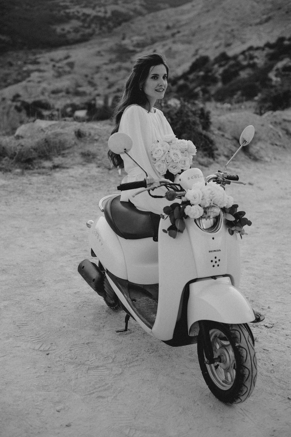 a woman sitting on a scooter with a bouquet of flowers
