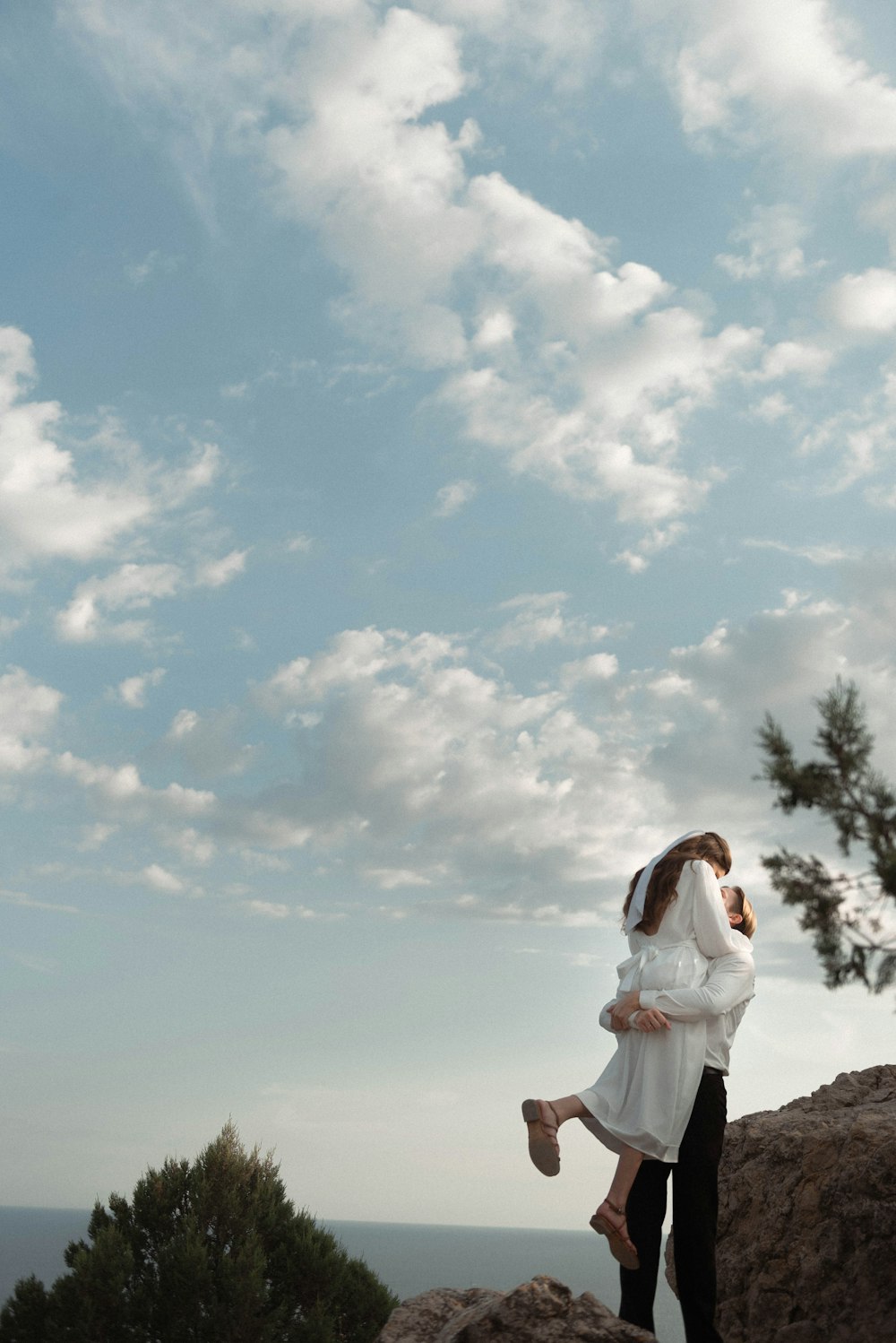 a man and a woman standing on top of a mountain